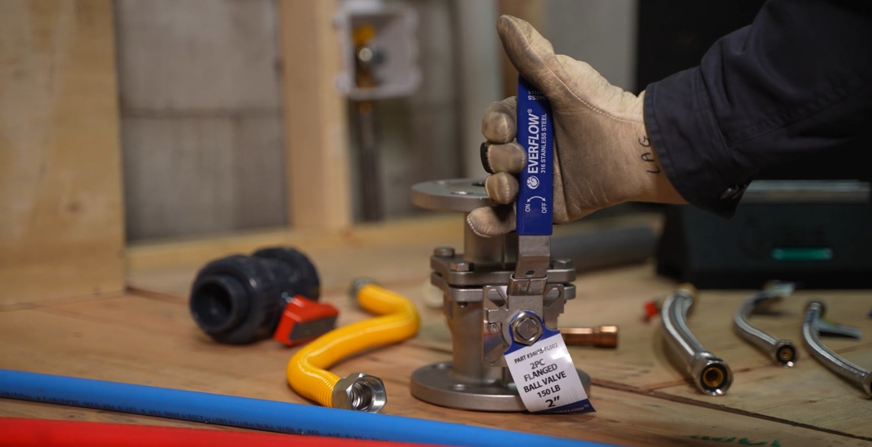 Technician operating a stainless steel ball valve for a commercial plumbing system.
