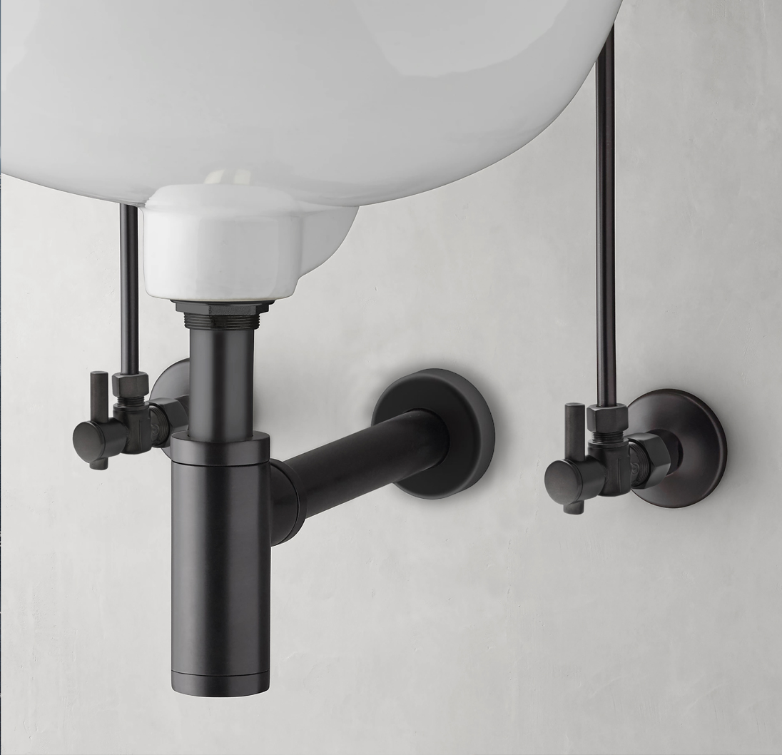 Matte black drain and plumbing connections installed beneath a bathroom sink.