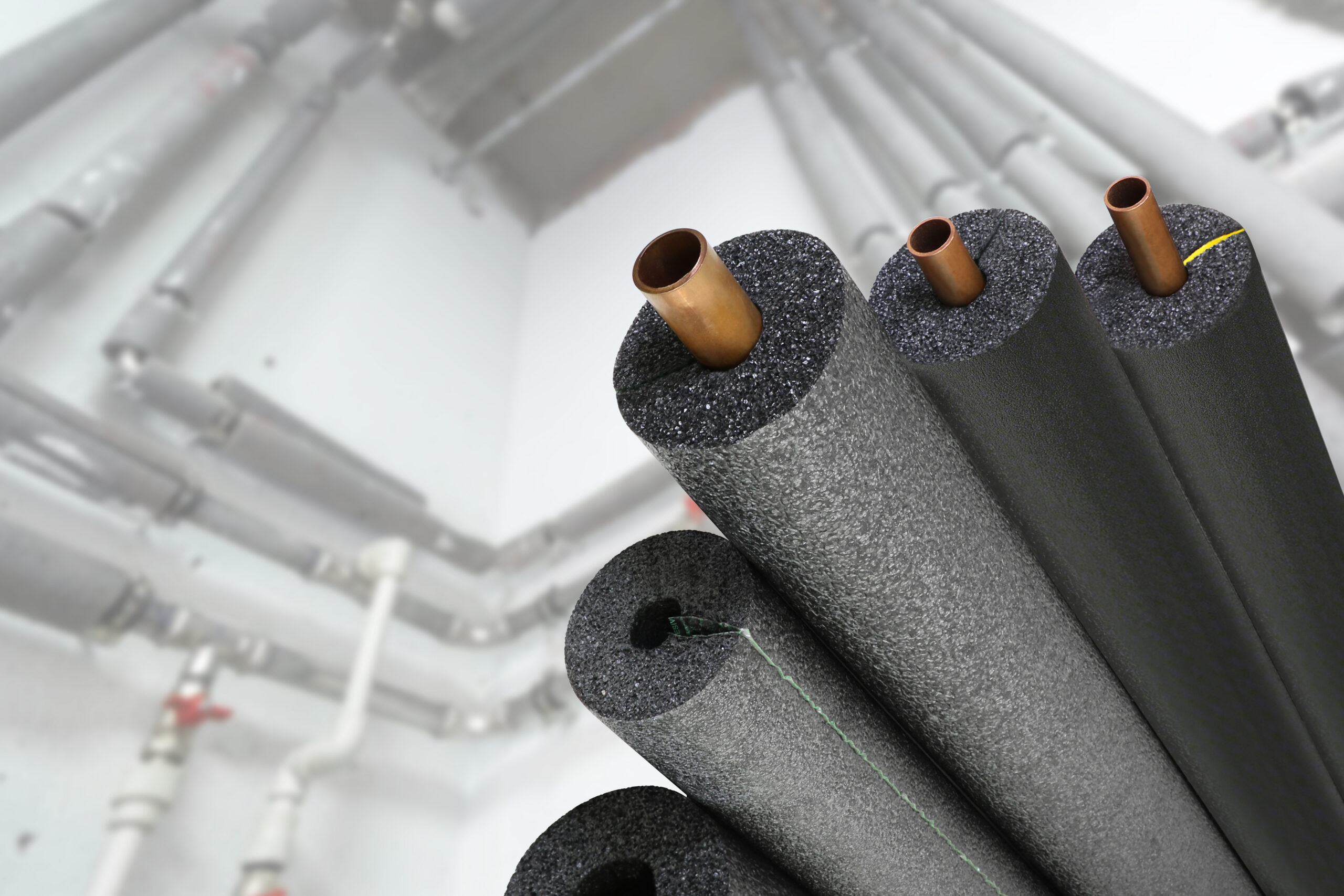 Flexcraft foam pipe insulation installed around copper piping in multiple sizes.