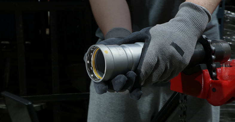 Titanpress logo over a worker installing a carbon steel press fitting.