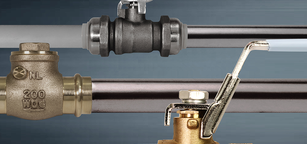 Brass and metal ball valves installed on piping with lever handles.