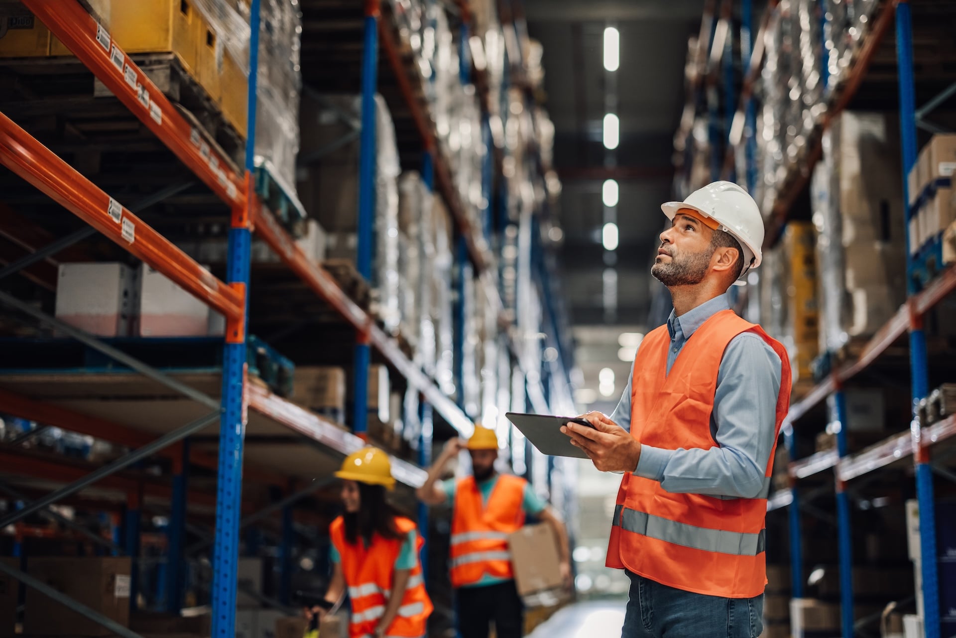 Male warehouse employee manages inventory and order fulfillment in a distribution center.