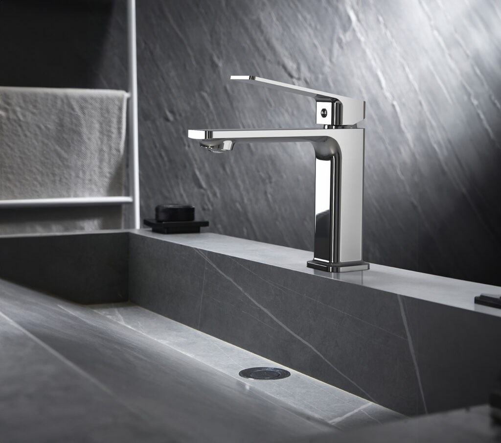 Modern chrome bathroom faucet installed over a contemporary stone sink.