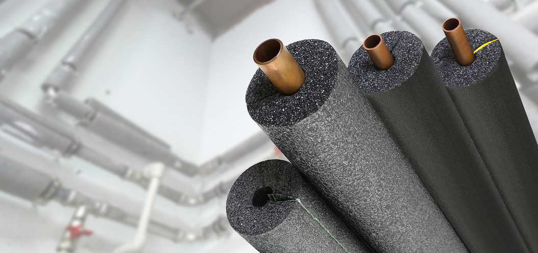 Close-up of insulated pipes with foam pipe insulation in a commercial building.