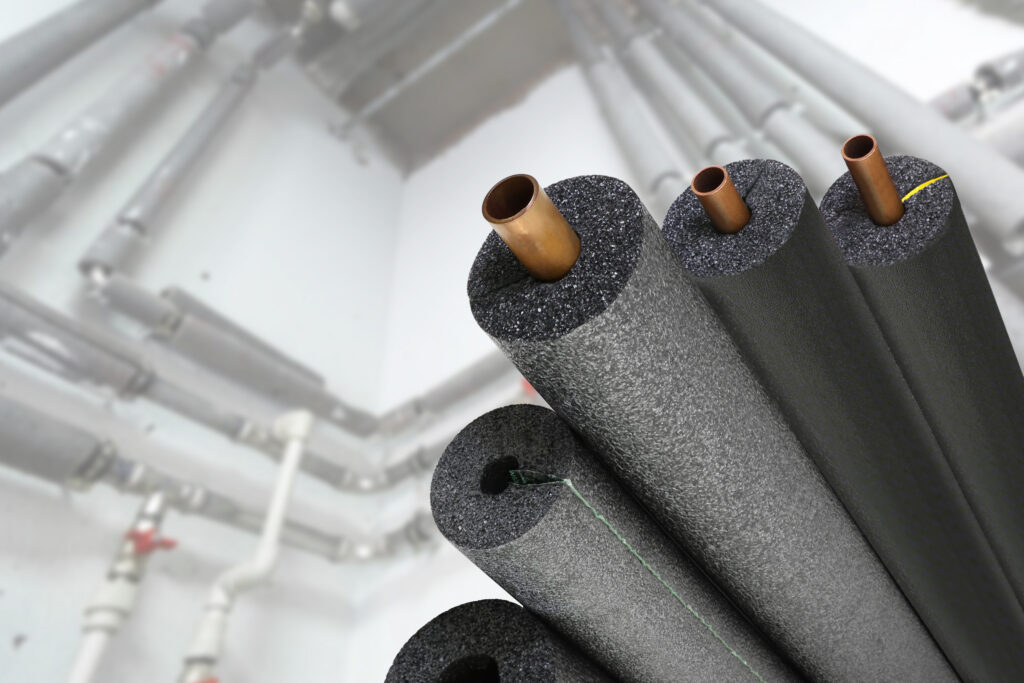 Close-up of insulated pipes with foam pipe insulation in a commercial building.