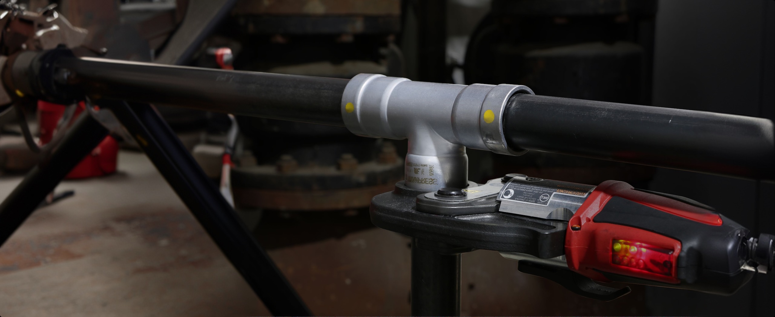Press tool installing a pipe fitting for a secure commercial plumbing connection.