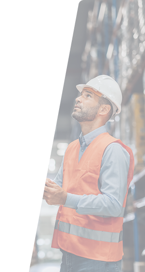 Warehouse worker in a hard hat and orange safety vest inspecting inventory.